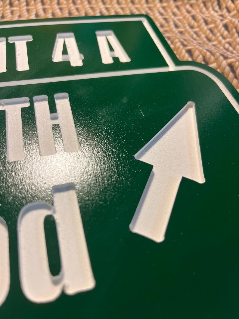 Puede incluir: Un letrero verde con letras blancas y una flecha blanca que apunta hacia arriba y hacia la derecha. El letrero dice "EXIT 4A", "TH" y "d". El letrero es probablemente para una autopista o carretera.