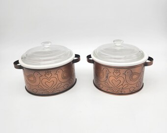 pair of vintage ceramic casserole dishes with punched tin copper holders and Pyrex lids