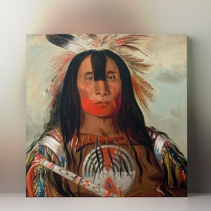 May include: A portrait of a Native American man with long black hair and red face paint. He wears a feathered headdress and a brown garment with a central emblem. The artwork is a square canvas print.