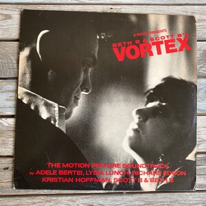 May include: A black and white photo of two people looking at each other. The image is the cover art for the soundtrack to the movie "Vortex" by Beth B & Scott B.