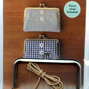 May include: Image of a craft project kit for making vintage clasp wallets. The kit includes two finished wallets, one with a striped pattern and the other with a gingham pattern. The wallets have decorative buttons and metal clasps. The text "Vintage Clasp Wallet" is displayed.