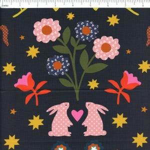 May include: Dark navy fabric with a repeating pattern of pink and blue flowers, yellow stars, and pink rabbits with white polka dots. A pink heart is between the rabbits. The flowers have orange centers. The fabric is suitable for quilting or crafting.
