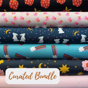 May include: A stack of patterned fabric rolls. Designs include strawberries, pink flowers, bunnies with moons and stars, and shooting stars. The words "Curated Bundle" are displayed on a white rectangle.