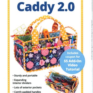 May include: Catch All Caddy 2.0, a floral-patterned craft caddy with a yellow and blue trim. The caddy has a sturdy design with expanding interior dividers, exterior pockets, and padded handles. The text on the caddy says "Organize and carry all your supplies!"