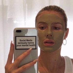 May include: A white phone case with a black and white sticker that reads "Social Media seriously harms your mental health".