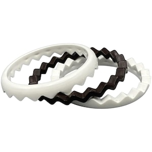 May include: Three stacked bangles with a zigzag design. Two are white, and one is dark brown. The bangles have a smooth, glossy finish and a modern, geometric aesthetic. The bangles are made of a solid material.