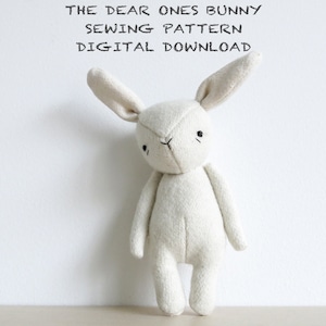 May include: A white plush bunny sewing pattern, with the text "THE DEAR ONES BUNNY SEWING PATTERN DIGITAL DOWNLOAD" above the bunny.