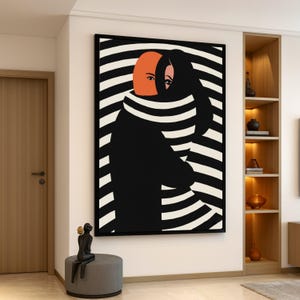 Peut inclure: Impression d'art abstrait représentant deux figures s'embrassant, l'une avec un visage orange et l'autre en noir. Le fond présente des rayures horizontales noires et blanches. L'œuvre est encadrée dans un cadre noir et accrochée à un mur blanc.
