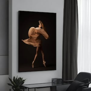 Op de afbeelding: Een vrouw in een vloeiende, huidkleurige stof danst in een donkere studio. De stof golft om haar heen terwijl ze beweegt, waardoor een gevoel van beweging en gratie ontstaat.