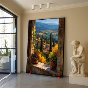 Puede incluir: Obra de arte enmarcada de gran tamaño que representa un paisaje toscano. La pintura muestra una vista a través de una ventana con plantas en macetas, cipreses y colinas. La obra de arte está apoyada en soportes rojos en una habitación con una estatua.