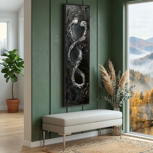 May include: Abstract black and white wall art featuring two intertwined figures. The artwork has a textured, raised surface with silver and red accents, framed in black. The piece is displayed above a light gray bench.
