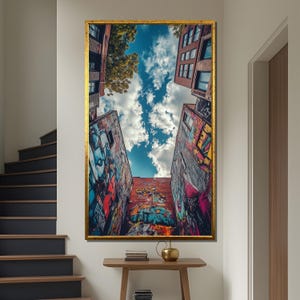 May include: A colorful street art mural on a building with a blue sky and white clouds in the background. The mural features a variety of colors, including red, blue, green, yellow, and orange. The building is made of brick and has a window on the side.