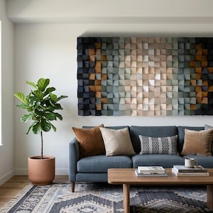 May include: A large rectangular wall art piece composed of numerous small, square wooden blocks arranged in a gradient pattern, transitioning from dark charcoal and black on the outer edges to light beige and cream tones in the center.