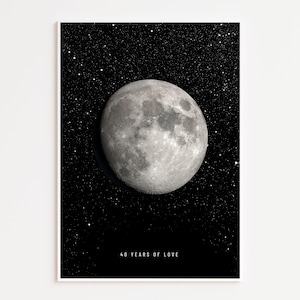 May include: A framed print featuring a detailed image of the moon against a starry night sky. The moon is a bright, textured sphere. The text "40 YEARS OF LOVE" is printed in white at the bottom of the print.
