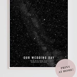 Puede incluir: Una impresión en blanco y negro de un mapa estelar, con el texto "OUR WEDDING DAY" y la fecha y hora de la boda. La impresión tiene un borde blanco y un círculo rosa con el texto "PRINT AT HOME!"