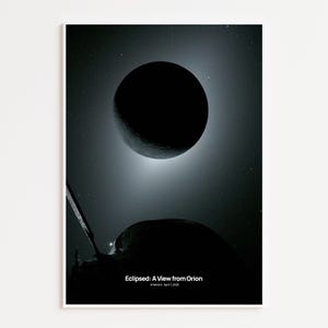 May include: A black and white print of a celestial event, featuring a large, dark sphere eclipsing a lighter, textured celestial body. The image is set against a starry background with the text "Eclipsed: A View from Orion" at the bottom.