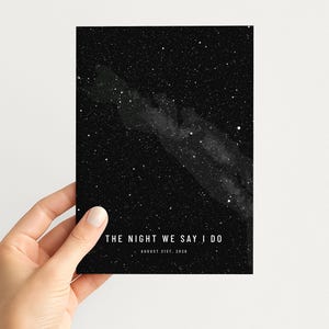 Op de afbeelding: Een zwart-wit print met een sterrenhemel en een melkwegontwerp. De tekst "THE NIGHT WE SAY I DO" en de datum "AUGUST 21ST, 2020" zijn in het wit onderaan de print gedrukt.
