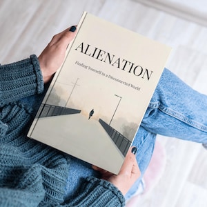 Könnte beinhalten: Ein Buch mit dem Titel "ALIENATION" und dem Untertitel "Finding Yourself in a Disconnected World". Das Cover zeigt eine minimalistische Illustration einer Person, die auf einer Brücke geht. Das Buch wird von einer Person gehalten, die einen tealfarbenen Pullover und Jeans trägt.