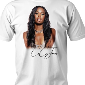 Könnte beinhalten: Weißes T-Shirt mit einem Farbbild einer Frau mit langen schwarzen Haaren und einer goldenen Halskette. Der Text "Coco Jones" ist in schwarzer Kursivschrift unter dem Bild geschrieben.