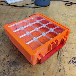 May include: An orange plastic storage case with a clear lid. The case has a handle and multiple compartments for organising small items.