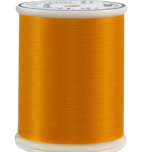 May include: A spool of bright orange thread.