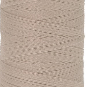May include: A spool of beige thread with a red label that reads "Mettler Group No. 100 500m/547yds".