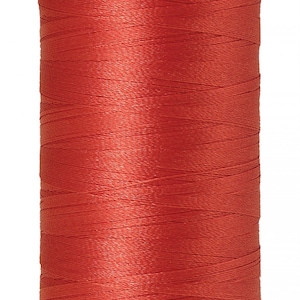 May include: A spool of red Mettler poly thread with the text "Mettler poly thread" and "GERMAN MADE" on the spool.