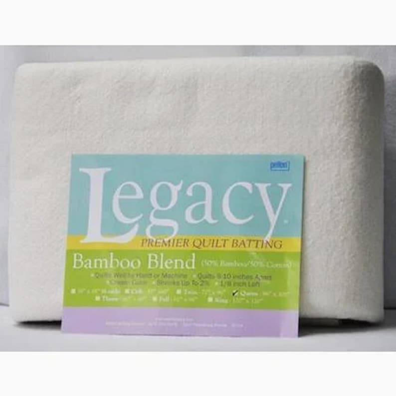 May include: White quilt batting with a label that reads "Legacy Premier Quilt Batting Bamboo Blend (60% Bamboo/40% Cotton)". The label also includes information about the product, such as how to wash it, the size of the quilt, and the loft.
