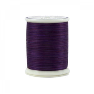 May include: A spool of purple thread with a white base and top. The thread is tightly wound, showing a textured surface. The thread is a deep, rich purple colour, suitable for various sewing projects.