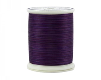 May include: A spool of purple thread with a white base and top. The thread is tightly wound, showing a textured surface. The thread is a deep, rich purple color, suitable for various sewing projects.