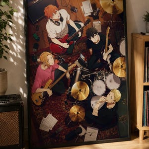 May include: A framed anime-style poster depicting a four-piece band in a rehearsal space. The illustration features a guitarist with orange hair, a bassist with blonde hair, a drummer with blonde hair, and a guitarist with black hair, surrounded by musical instruments, amplifiers, and scattered sheet music.