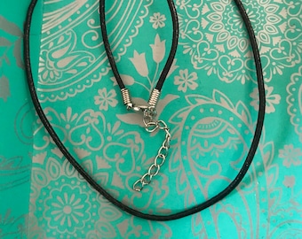 May include: A black leather cord necklace with a silver clasp and chain extender.