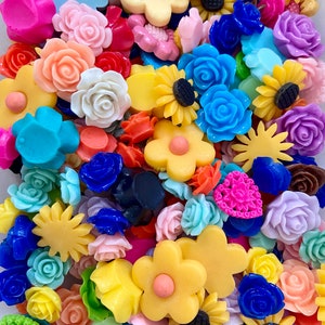 Puede incluir: Un gran surtido de adornos de resina de colores en forma de flor. Los adornos son de varios colores, incluyendo rosa, azul, amarillo, verde, rojo y naranja. Son perfectos para añadir un toque de fantasía a las manualidades y proyectos.