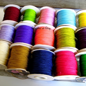 May include: Assortment of spools of colorful waxed cord, perfect for jewelry making, macrame, and crafts. The spools are arranged in three rows of four, with a variety of colors including red, green, pink, blue, yellow, purple, orange, brown, navy, and pink.