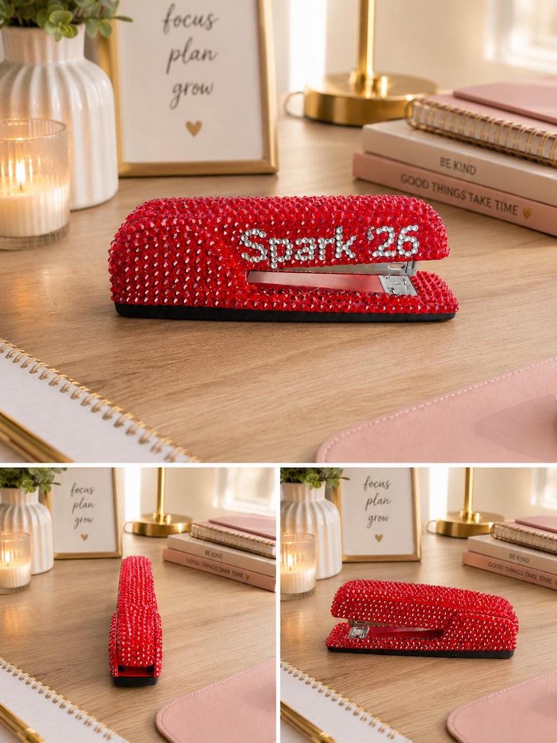 Pu&ograve; includere: Una cucitrice rossa interamente ricoperta di piccoli strass rossi scintillanti. Il lato della cucitrice presenta la scritta "Spark 26" formata da cristalli chiari e riflettenti sullo sfondo di strass rossi, con un meccanismo in metallo argentato.