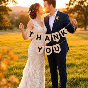 May include: A beige fabric banner featuring the black printed text THANK YOU, suspended by a thin twine string. The banner consists of eight individual pennant-shaped flags, each displaying a single letter, arranged in two rows to spell out the message.