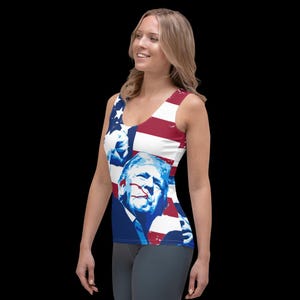 K&ouml;nnte beinhalten: Ein &auml;rmelloses Tanktop mit einem rot-wei&szlig;-blauen amerikanischen Flaggenmuster. Das Flaggenmuster zeigt ein Portr&auml;t eines Mannes vor blauem Hintergrund. Das Tanktop ist aus einem weichen, bequemen Material gefertigt.