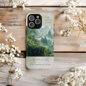 May include: A phone case with a landscape design. It features a white deer on a cliff, mountains, and text that reads "Fireheart, you do not yield" and "To whatever end. S.J.M Throne of Glass."