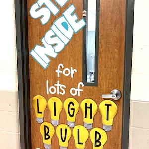 Puede incluir: Una puerta de madera decorada con las palabras "STEP INSIDE" en letras blancas con un contorno azul claro. Debajo, la frase "for lots of LIGHT BULB MOMENTS!" se muestra con recortes de bombillas amarillas.