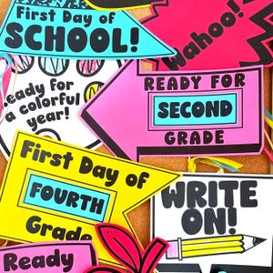 May include: A collection of colourful paper signs for school events. The signs feature text including First Day of School, Ready for Second Grade, First Day of Fourth Grade, and Write On, accompanied by illustrations of a pencil and vibrant shapes.
