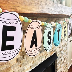 May include: Easter banner with pastel-colored egg-shaped cutouts spelling "EASTER". Each egg has a black outline and a decorative scalloped edge. The banner is strung with colorful speckled beads, perfect for Easter decorations.