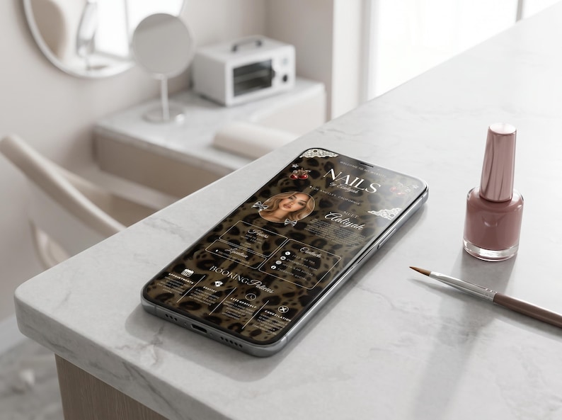 Puede incluir: Un smartphone muestra un sitio web con fondo de estampado de leopardo, el texto "NAILS by Aliyah" y un retrato circular. Junto al tel&eacute;fono hay un frasco de esmalte de u&ntilde;as rosa empolvado y un pincel fino para u&ntilde;as sobre una superficie blanca.