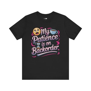 Könnte beinhalten: Schwarzes T-Shirt mit dem Schriftzug "My Patience is on Backorder" in verspielter Schrift, mit einem Emoji, einer Kaffeetasse und einer Sanduhr-Grafik. Das Design verwendet Rosa-, Blau- und Weißtöne.