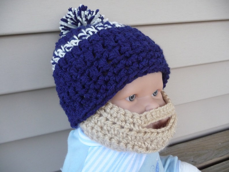 Puede incluir: Un gorro de punto azul y blanco con un pomp&oacute;n blanco en la parte superior. El gorro tiene una barba de punto unida a la parte inferior.