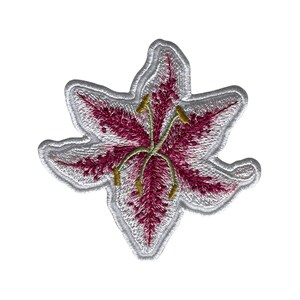 May include: Embroidered lily flower patch with a white outline. The flower has a deep pink centre with white accents and yellow stamens. This floral patch is ideal for adding to clothing, bags, or other fabric items.