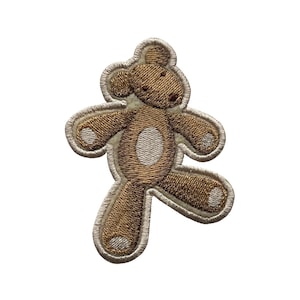 May include: Embroidered teddy bear patch in shades of brown and beige. The bear is in a playful pose with one leg raised. The patch has a detailed stitched design and a light beige border. Ideal for adding to clothing or accessories.