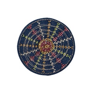 May include: A circular, navy blue embroidered coaster with a floral pattern. The centre has pink and gold embroidery, encircled by white stitching and floral details in pink, green, and gold. The coaster is approximately 10 cm in diameter.