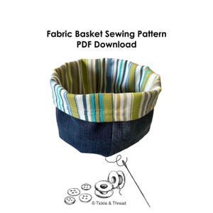May include: A fabric basket with a denim exterior and a striped interior in shades of green, blue, and white. The text "Fabric Basket Sewing Pattern PDF Download" is at the top. Sewing notions, including buttons, thread spools, and a needle, are at the bottom.
