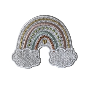 May include: Embroidered rainbow patch with pastel colours and white clouds. The rainbow features yellow, pink, green, and blue arches, with a small gold heart at the centre. The patch is designed for fabric applications.