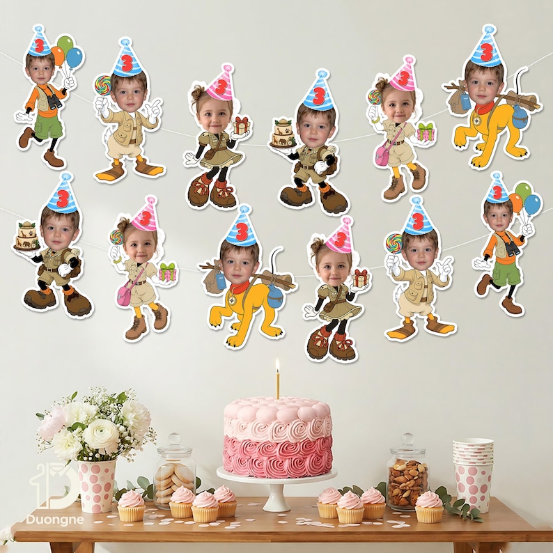 May include: A festive birthday party scene with a pink and white layered cake, cupcakes, and a garland of cartoon cutouts. The cutouts feature a child's face wearing a party hat and various outfits. A lit candle sits atop the cake.